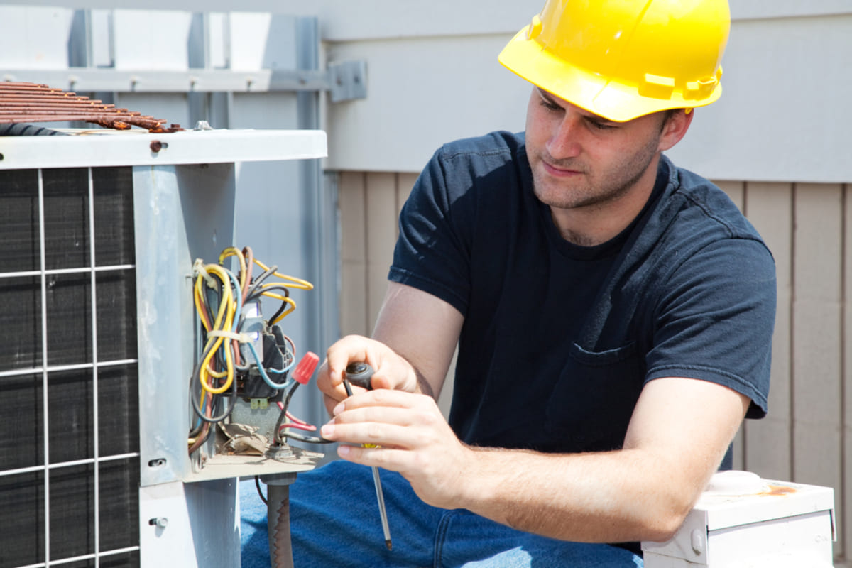 A man fixes an industrial AC, using experts for better real estate investment strategies concept
