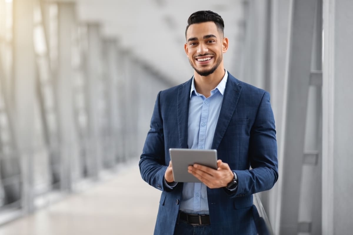 A man smiling with a tablet - peace of mind with commercial properties management concept