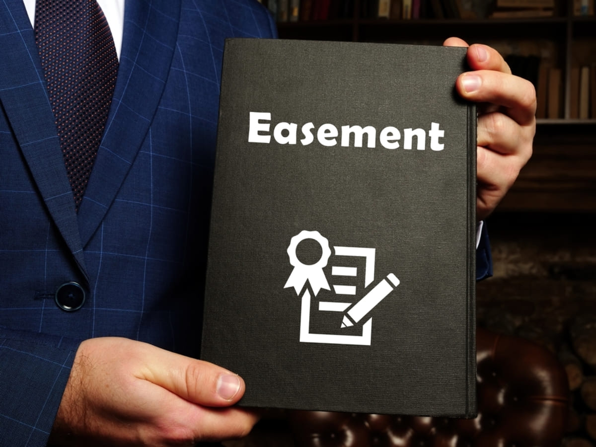 A professional holding a folder that says easement