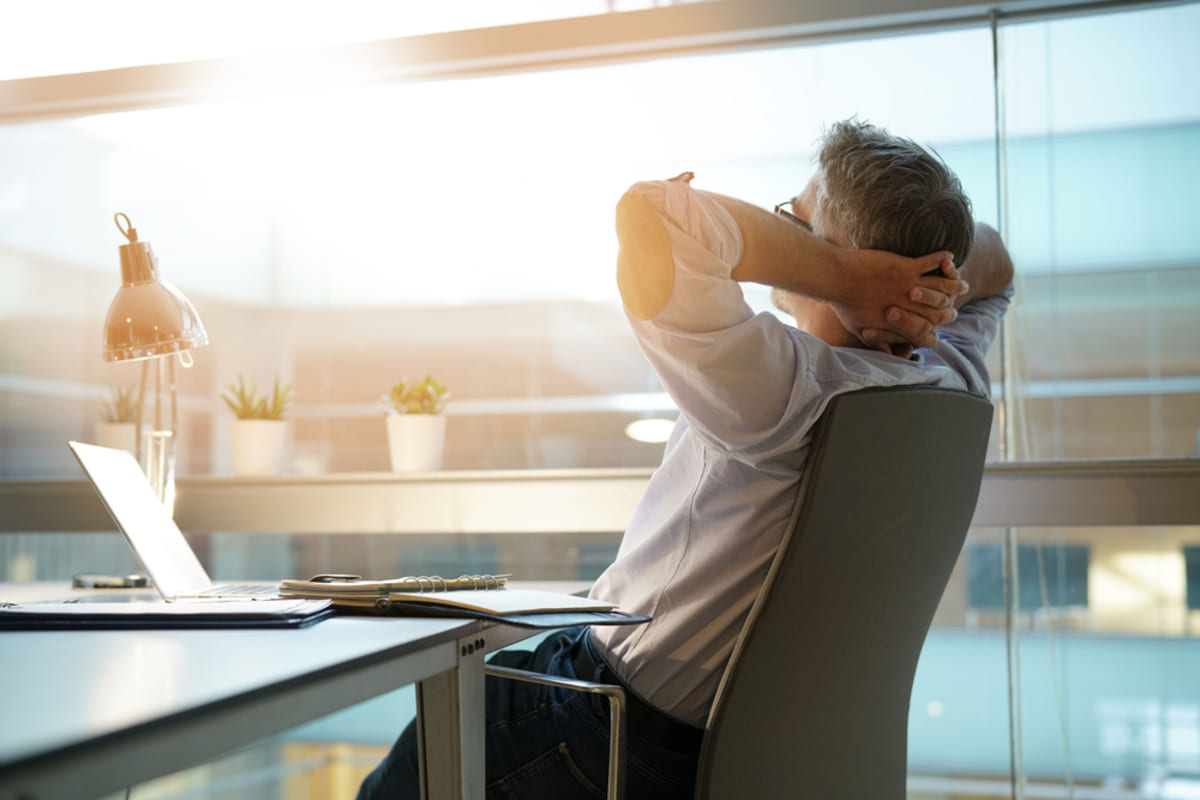 A relaxed man sitting back in an office chair