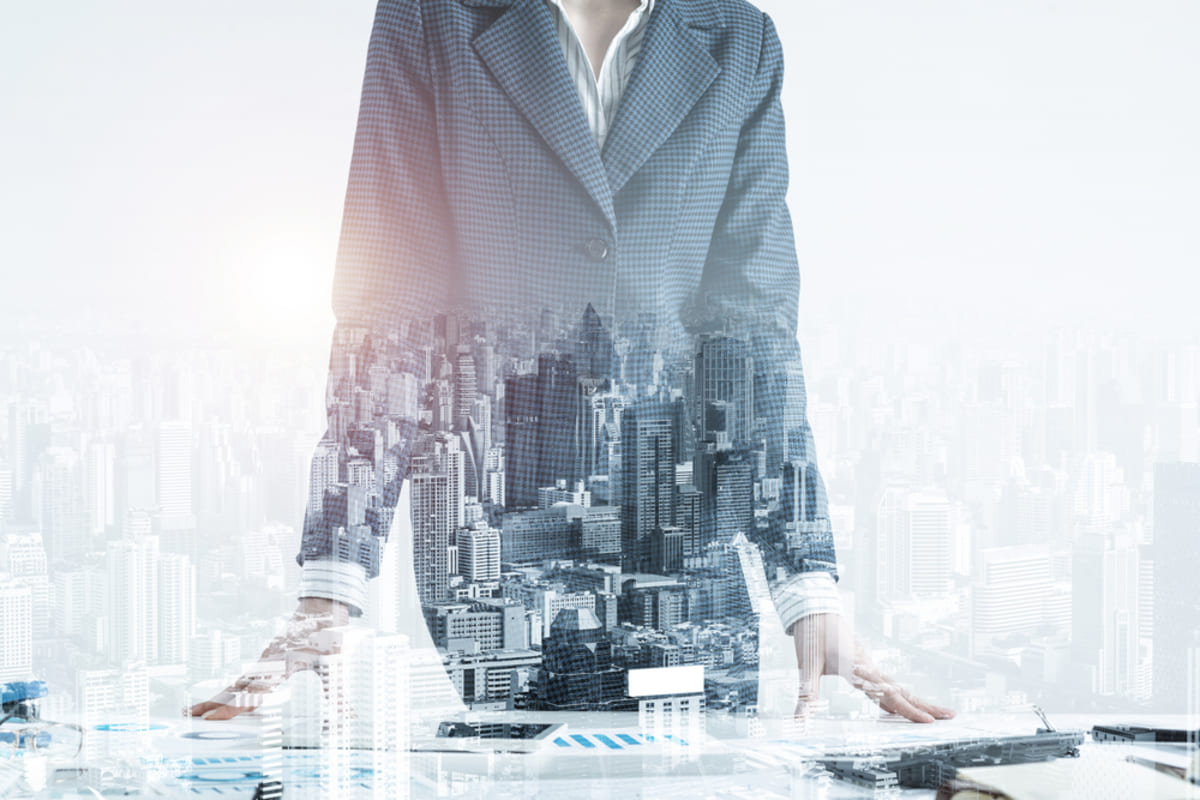 A woman in a suit with a commercial skyline background