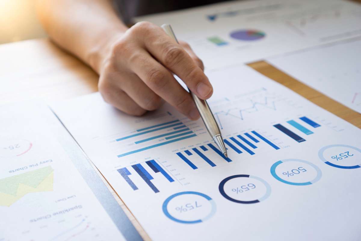 A hand with a pen next to a financial report, commercial property managers concept