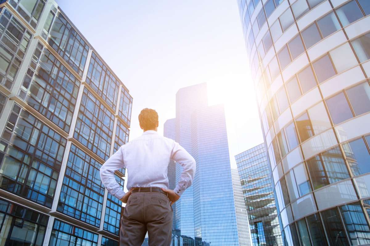 Man looking at buildings, commercial property investment opportunities concept