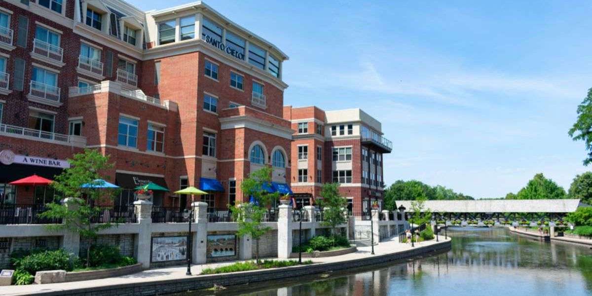 Buildings with Shops and Restaurants along the Naperville Riverwalk with a Covered Bridge in the Distance