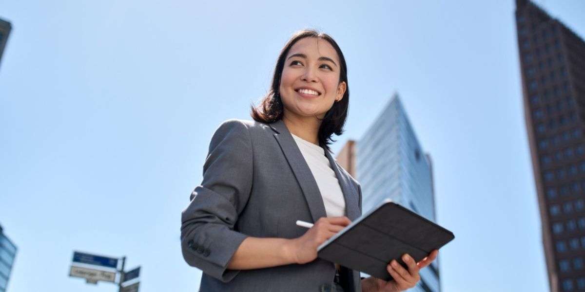 professional manager holding digital tablet computer using software applications standing on the street in big city